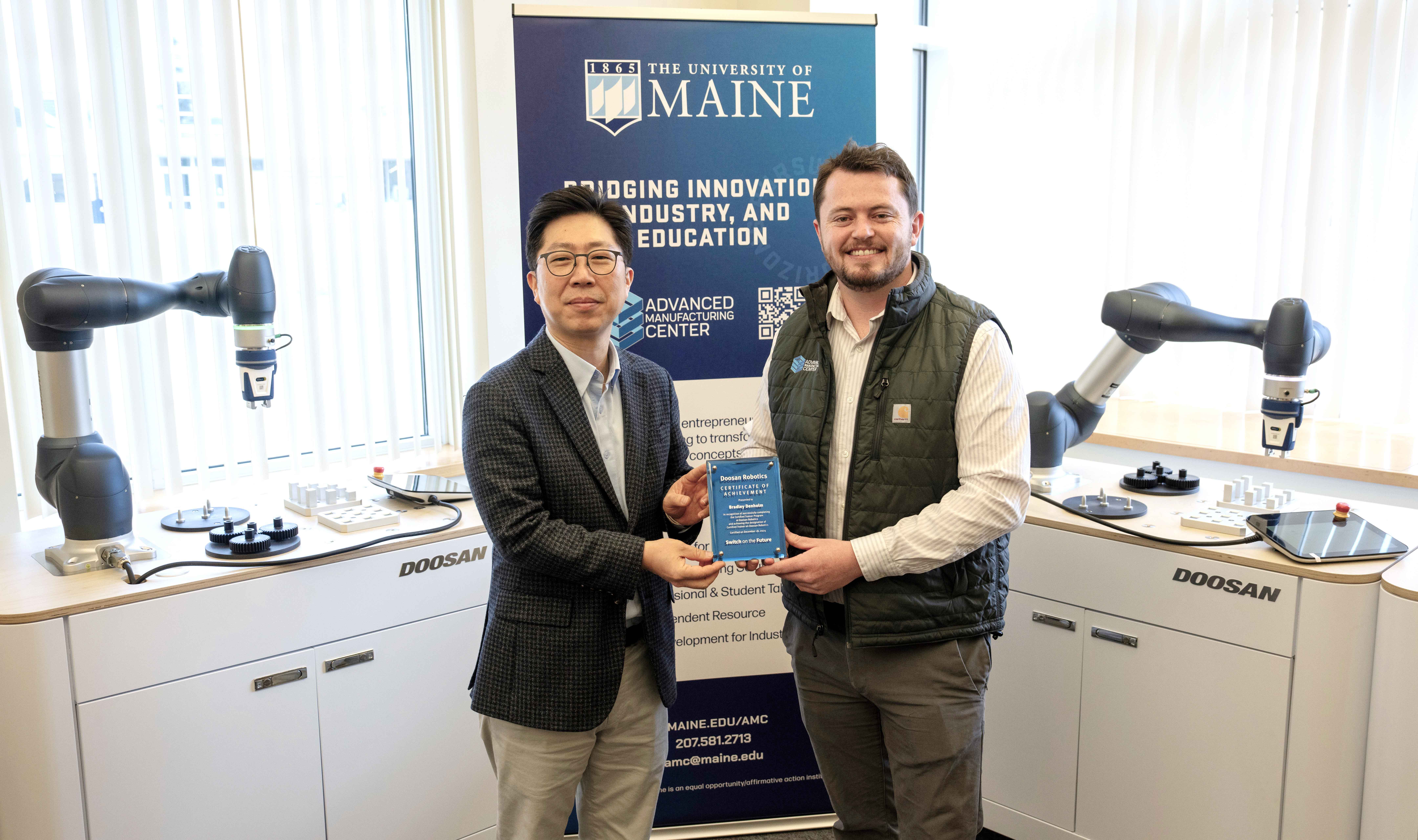 Hyunsoo Kim, vice president of sales at Doosan Robotics and Bradley Denholm, Associate Director of Workforce Development at the University of Maine Advanced Manufacturing Center(from left)