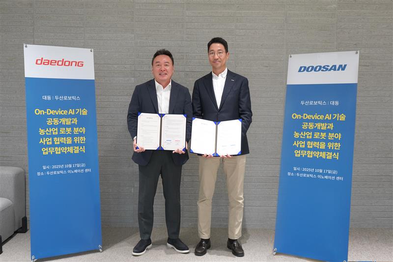 After the signing of the MoU, Kevin Kim, CEO of Doosan Robotics (right), poses for a commemorative photo with Yoohyun Won, Vice Chairman of Daedong 